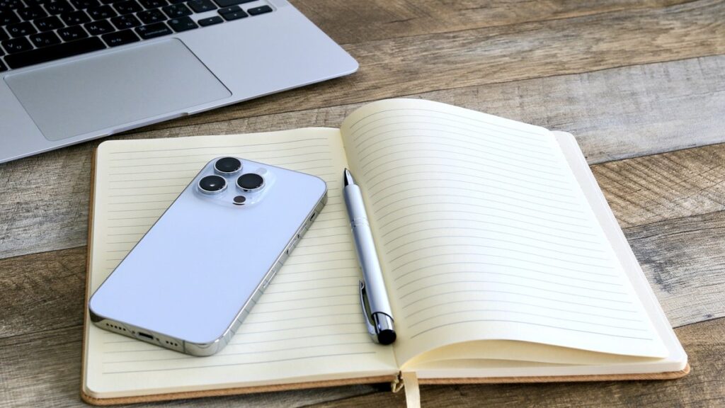 スマートフォンとペンを置いた、開いたノート
