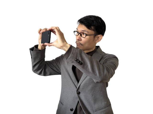 スマートフォンを構えて撮影するジャケット姿の男性
