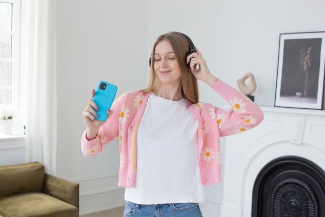 ヘッドホンをしてスマートフォンで音楽を聴く女性